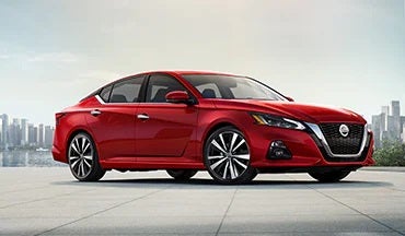 2023 Nissan Altima in red with city in background illustrating last year's 2022 model in Coral Springs Nissan in Coral Springs FL