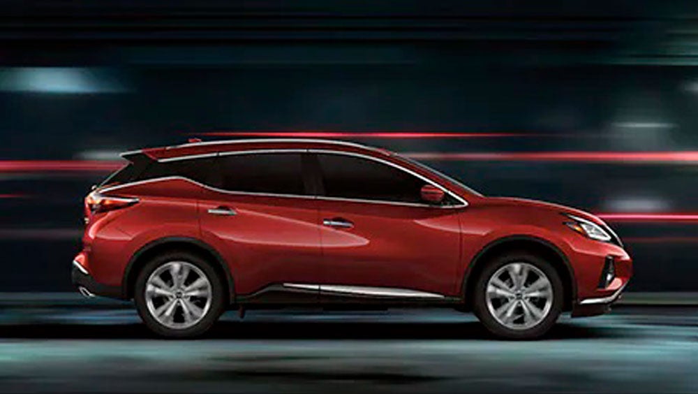 2023 Nissan Murano shown in profile driving down a street at night illustrating performance. | Coral Springs Nissan in Coral Springs FL