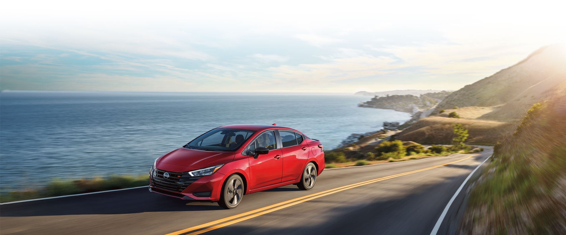 2024 Nissan Versa driving on a coastal road along a bluff